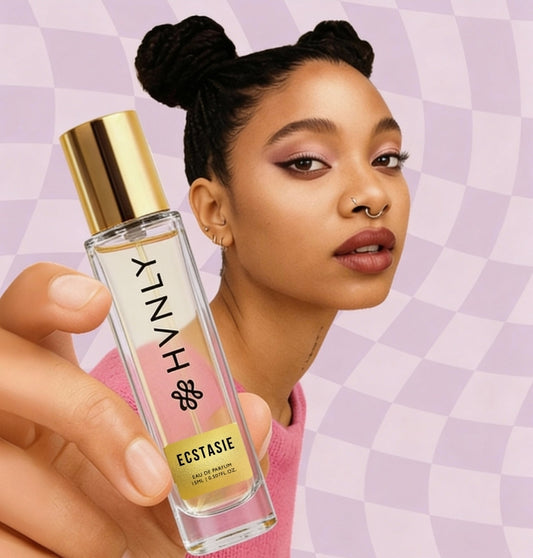 Woman holding a perfume bottle with a checkered purple background showing the handy size of the HVNLY Ecstasie perfume bottle