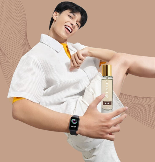 Person holding a HVNLY's MAN perfume with a smartwatch on a beige background
