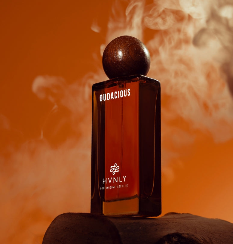 HVNLY Oudacious perfume bottle with smoke effect on an orange background showcasing the grandeur of the perfume