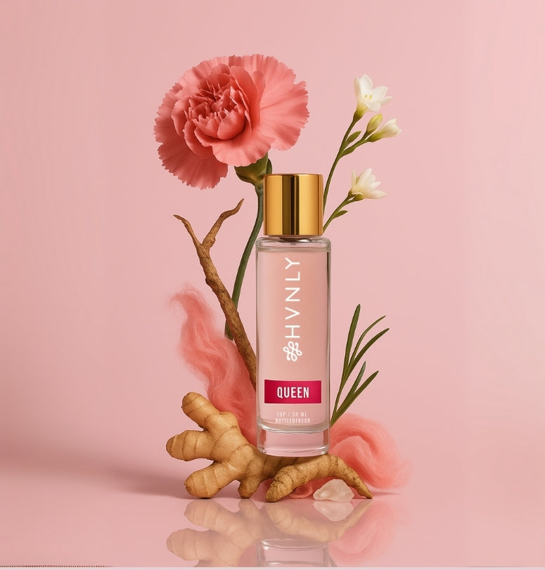 Perfume bottle with a pink flower on a pink background showcasing ingredients of the perfume