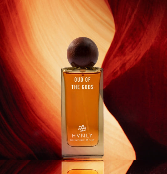 Perfume bottle labeled 'Oud of the Gods' by HVNLY on a red and orange background showcasing the royalty the perfume serves