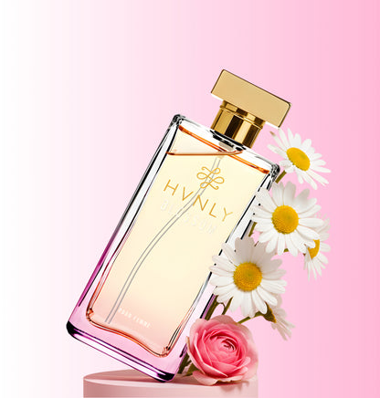 Blossom Perfume bottle with gold cap and 'HVNLY' branding on a pink background with flowers.