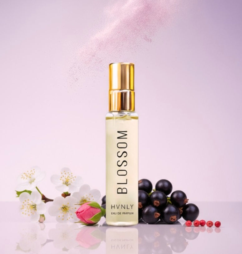 Perfume bottle labeled 'Blossom' by HVNLY with flowers and berries on a light pink background depicting its ingredients