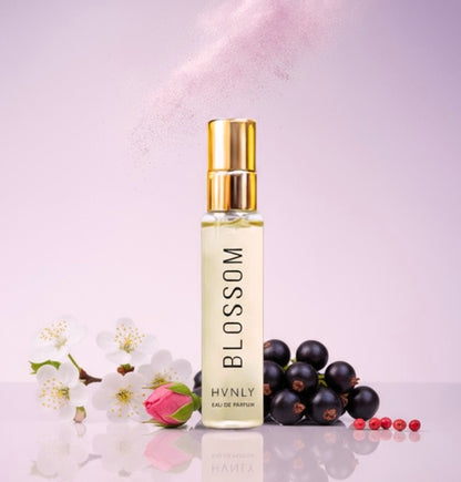 Perfume bottle labeled 'Blossom' by HVNLY with flowers and berries on a light pink background depicting its ingredients