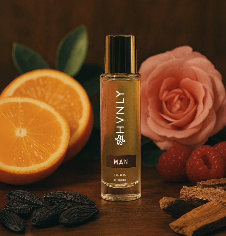 HVNLY's MAN perfume bottle with oranges, a rose, and cinnamon sticks on a wooden surface