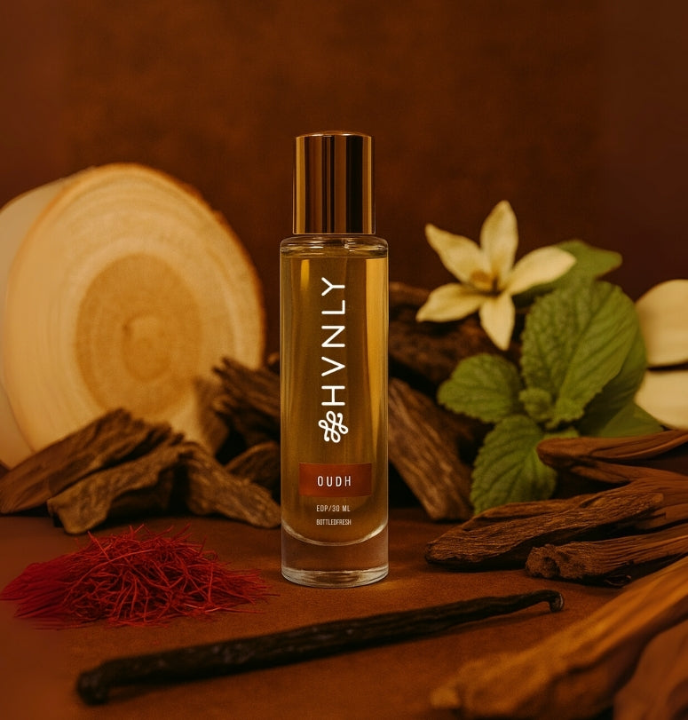 Bottle of HVNLY Oudh perfume with vanilla beans and flowers on a wooden background