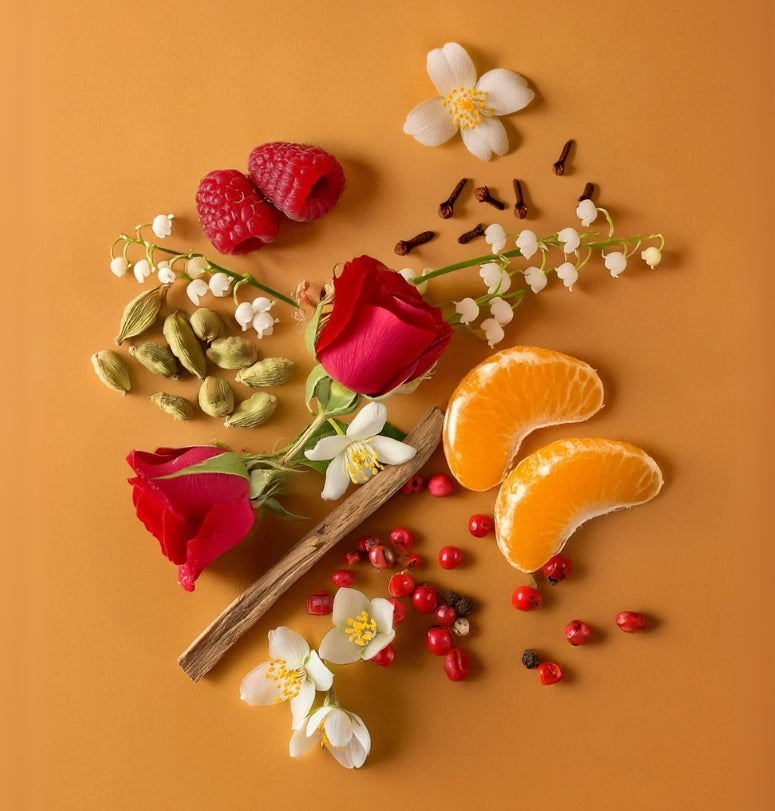 Fruits, flowers, and spices arranged on a brown background. Colorful display of natural ingredients used in HVNLY Cafe In Ibiza luxury perfume

