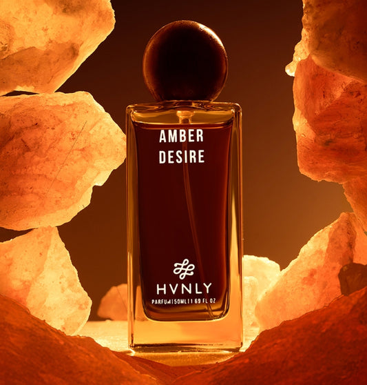 HVNLY Amber Desire perfume bottle surrounded by amber-colored rocks showcasing a sensory effect to its users