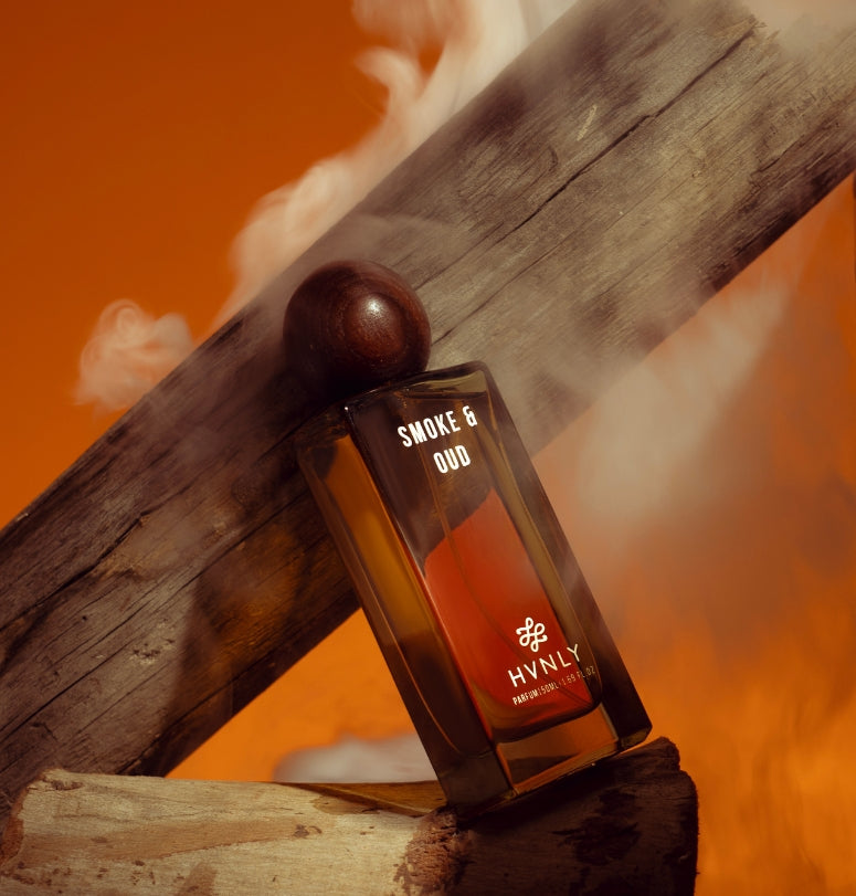HYNLY Smoke & Oud perfume bottle on wooden surface with orange background