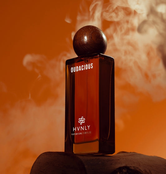HVNLY Oudacious perfume bottle with smoke effect on an orange background showcasing the grandeur of the perfume