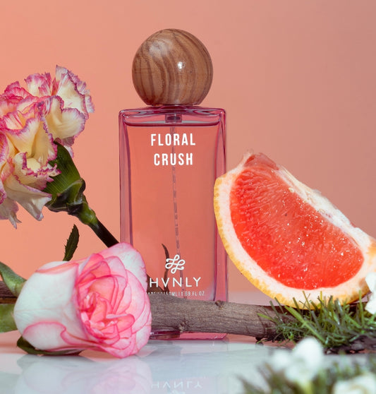 Perfume bottle labeled 'Floral Crush' by Hvnly with flowers and a grapefruit slice on a peach background showcasing a sensory effect to the users
