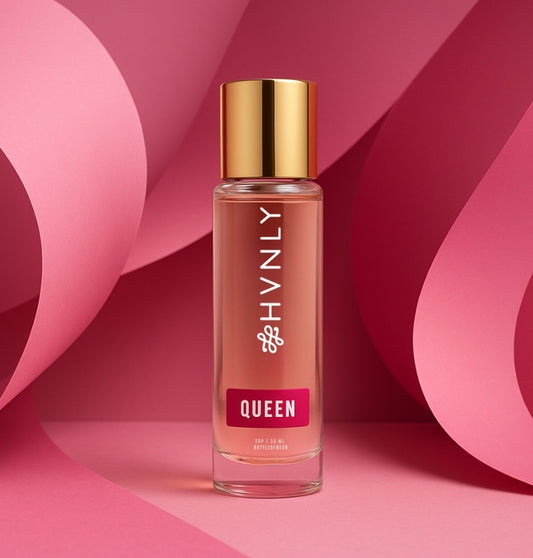 Bottle of 'Queen' perfume by HVNLY with gold cap on a pink background