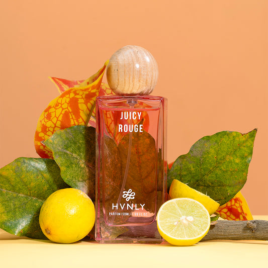 Hvnly Juicy Rouge perfume bottle with lemons and leaves on a peach background
