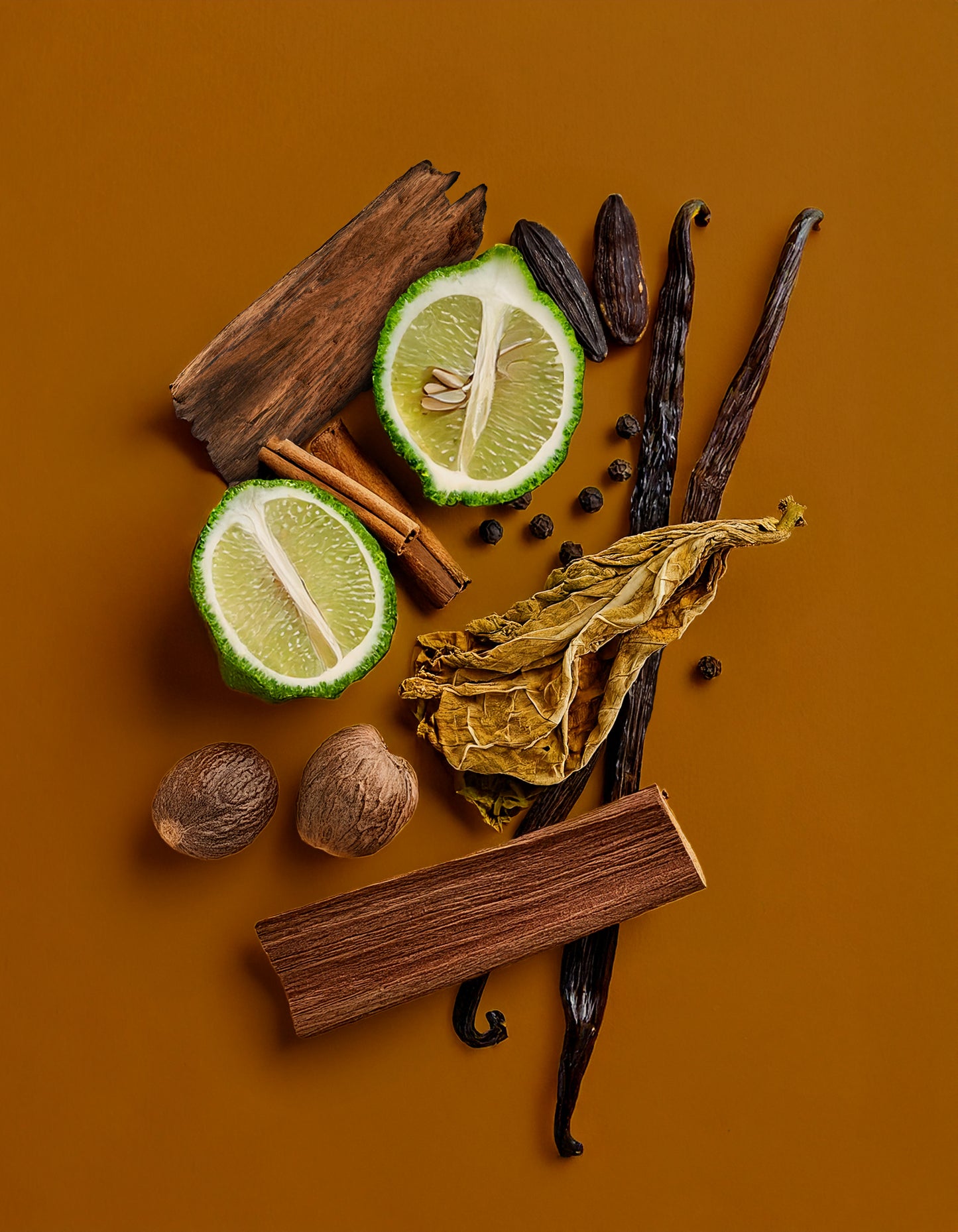 Spices and fruits including limes, vanilla beans, and cinnamon on a brown background. Colorful display of natural ingredients used in HVNLY Enchanted Garden luxury perfume

