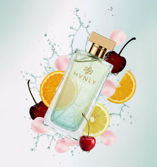 Perfume bottle with fruit elements on a light background