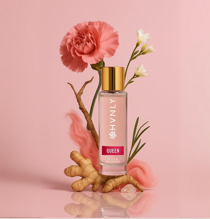 Perfume bottle with a pink flower on a pink background showcasing ingredients of the perfume